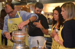 Food on the Table founder Manuel Rosso, Evette Rios of ABC's The Chew and Katie Boerhet of The Wall Street Journal's All Things D are guided by Chef David Bull during the hands-on cooking class, sponsored by KitchenAid